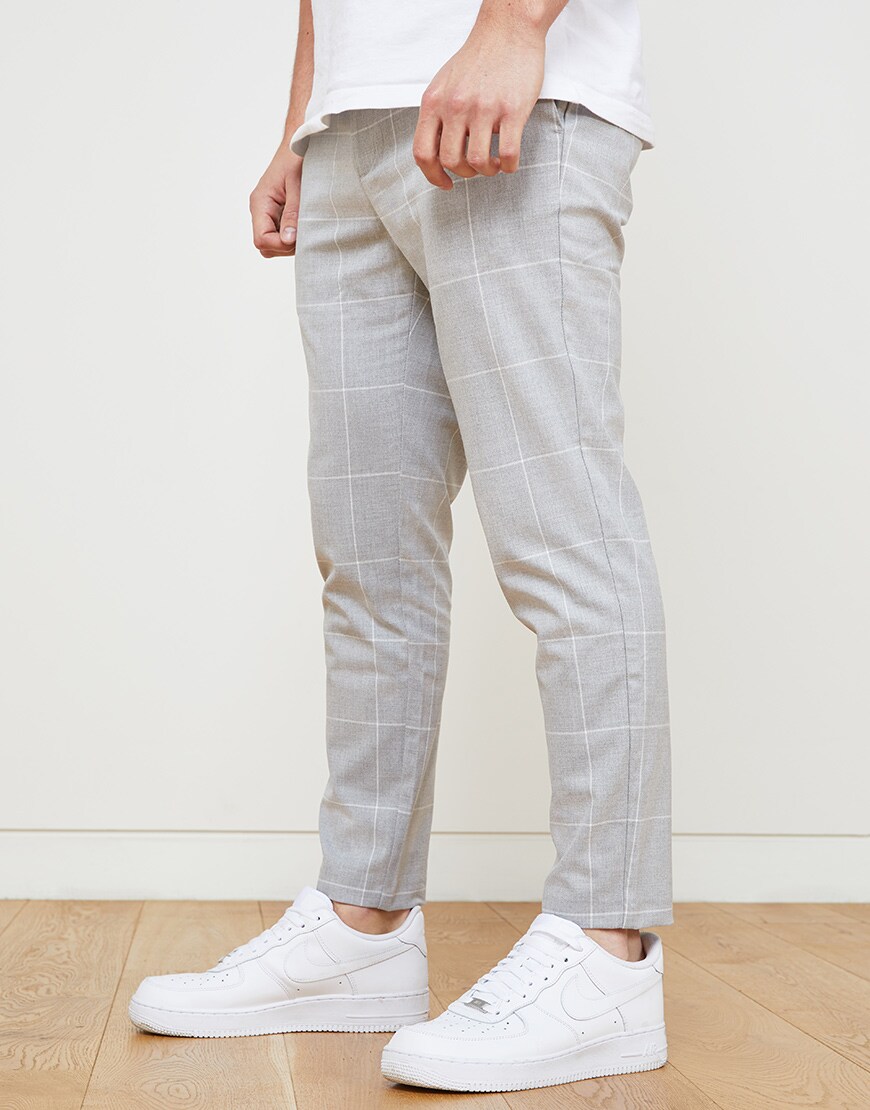 A picture of an ASOSer wearing a Nike T-shirt, Air Force 1 trainers and smart, check trousers. Available at ASOS.
