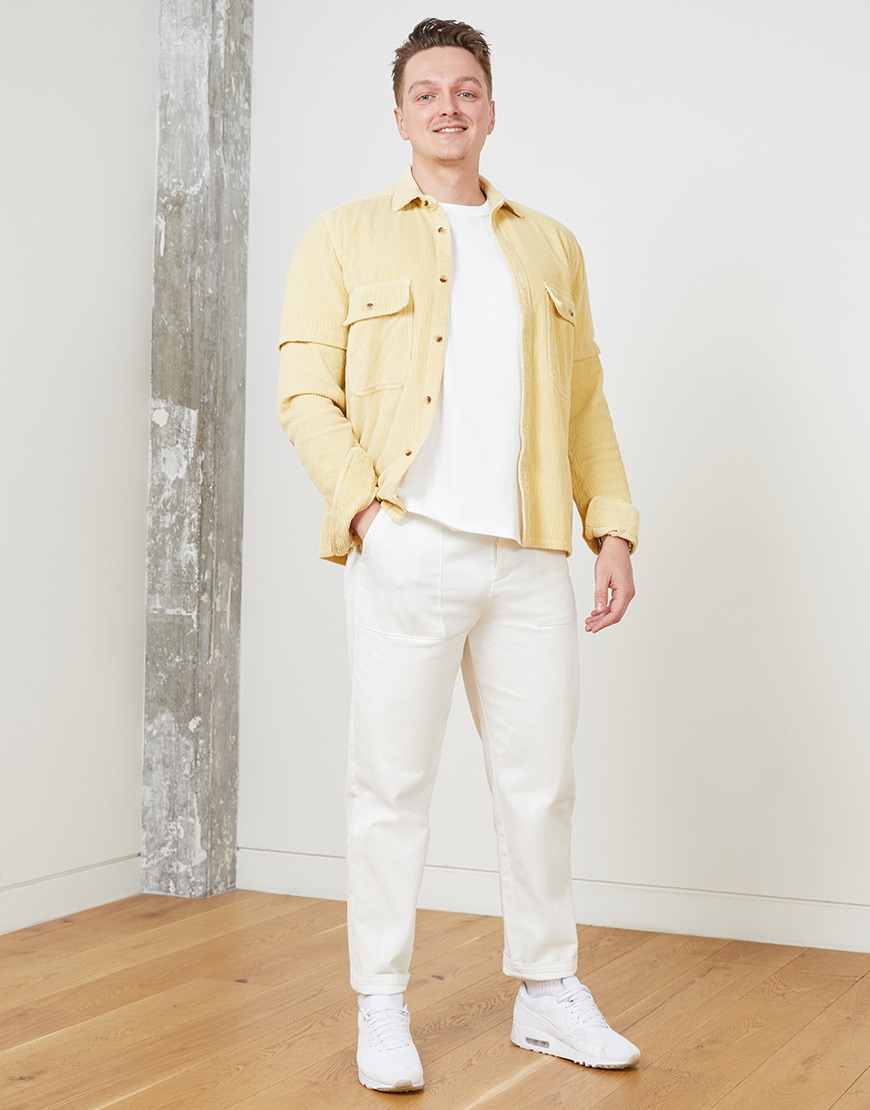 A picture of an ASOSer wearing a yellow shirt with off-white trousers and Nike trainers. Available at ASOS.