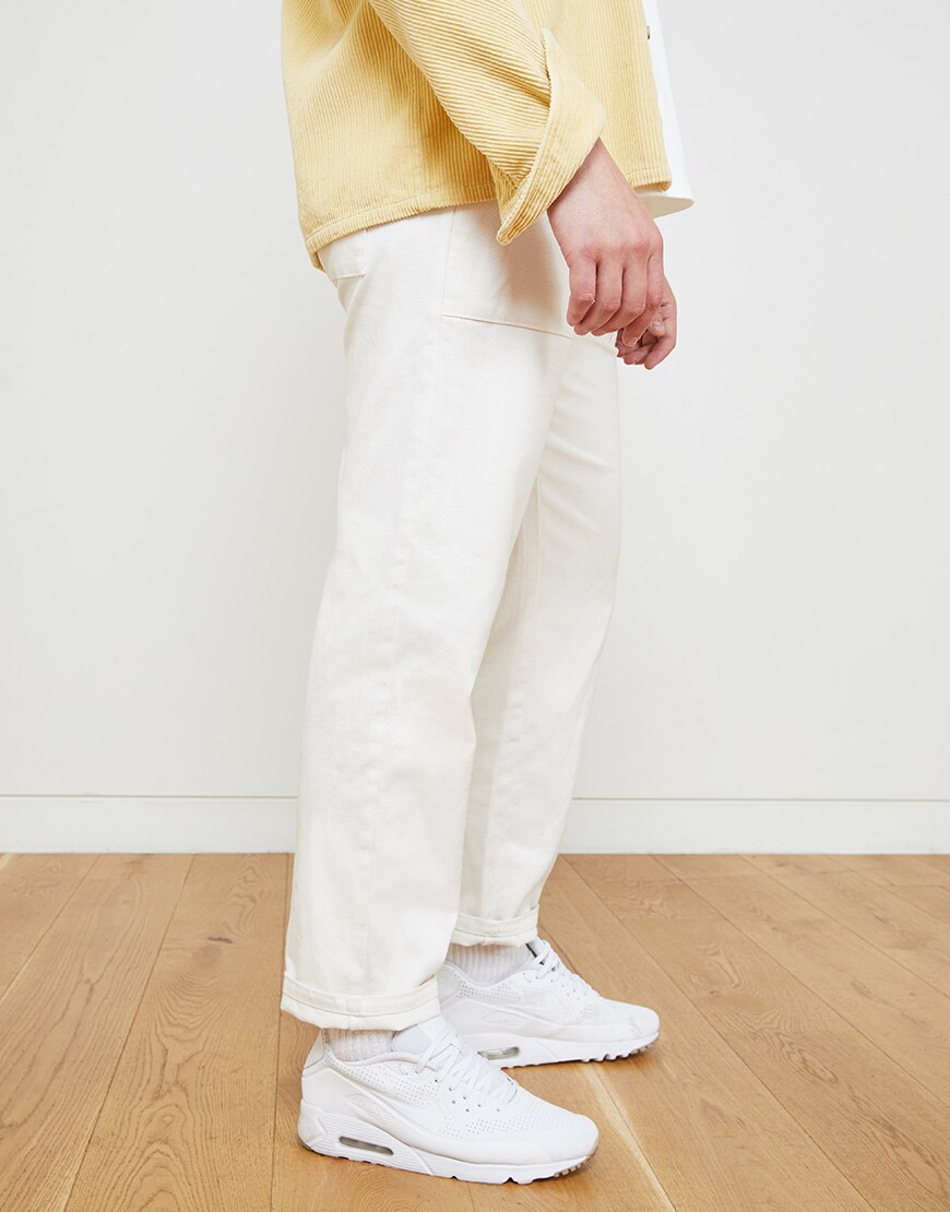 A picture of an ASOSer wearing a yellow shirt with off-white trousers and Nike trainers. Available at ASOS.