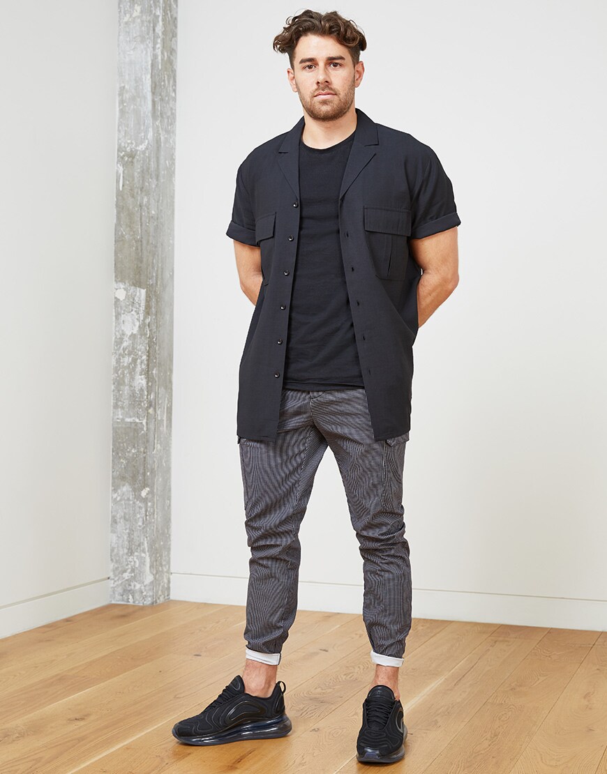 A picture of an ASOSer wearing a black revere-collar shirt and check utility-style trousers. Available at ASOS.
