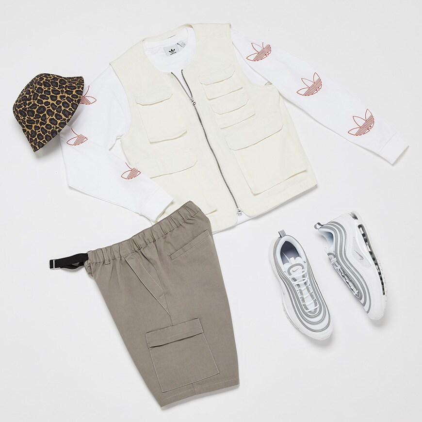 A flay lay outfit featuring an adidas Originals long-sleeve top, a utility gilet and shorts, Nike trainers and an animal print bucket hat. Available at ASOS.
