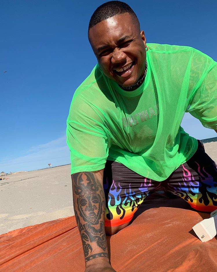 In diesem Streetstyle-Bild für Herren trägt der ASOS Insider Soouizz eine Flammen-Badehose und ein T-Shirt in Neon