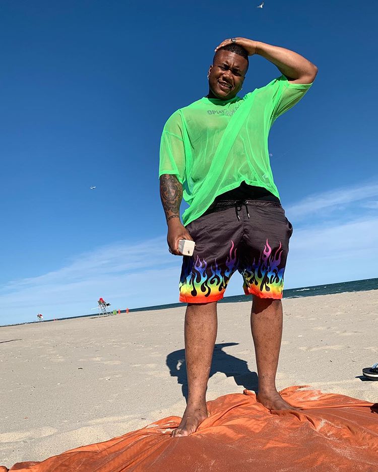 In diesem Streetstyle-Bild für Herren trägt der ASOS Insider Soouizz eine Flammen-Badehose und ein T-Shirt in Neon