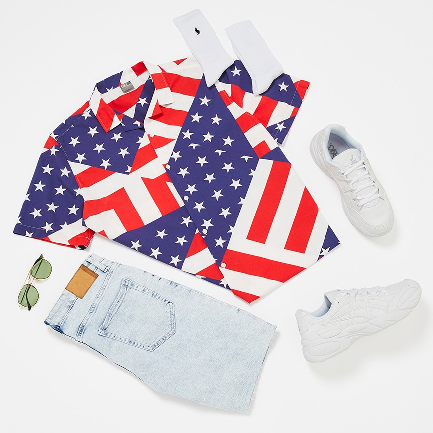 A picture of a flat lay outfit including an American flag print shirt, bleached denim shorts, Asics trainers, Polo Ralph Lauren socks and Ray-Ban sunglasses. Available at ASOS.