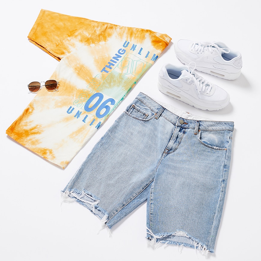 A picture of a flat lay outfit including a tie-dye T-shirt, ripped denim shorts, Nike Air Max trainers and round sunglasses. Available at ASOS.