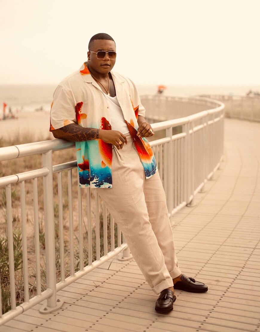 A picture of an ASOS Insider wearing a fish-print shirt, white trousers and brown loafers. Available at ASOS.
