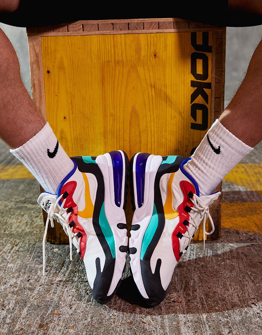 A picture of a model wearing the new Nike Air Max 270 React Bauhaus trainers. Available at ASOS.