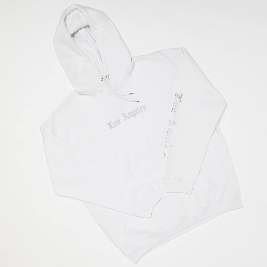 A picture of a white hoodie featuring reflective text on the chest and sleeves. Available at ASOS.