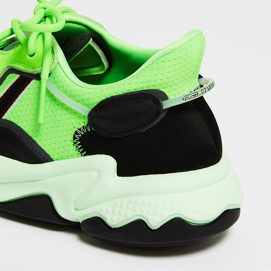 A picture of a pair of neon green adidas Ozweego trainers. Available at ASOS.