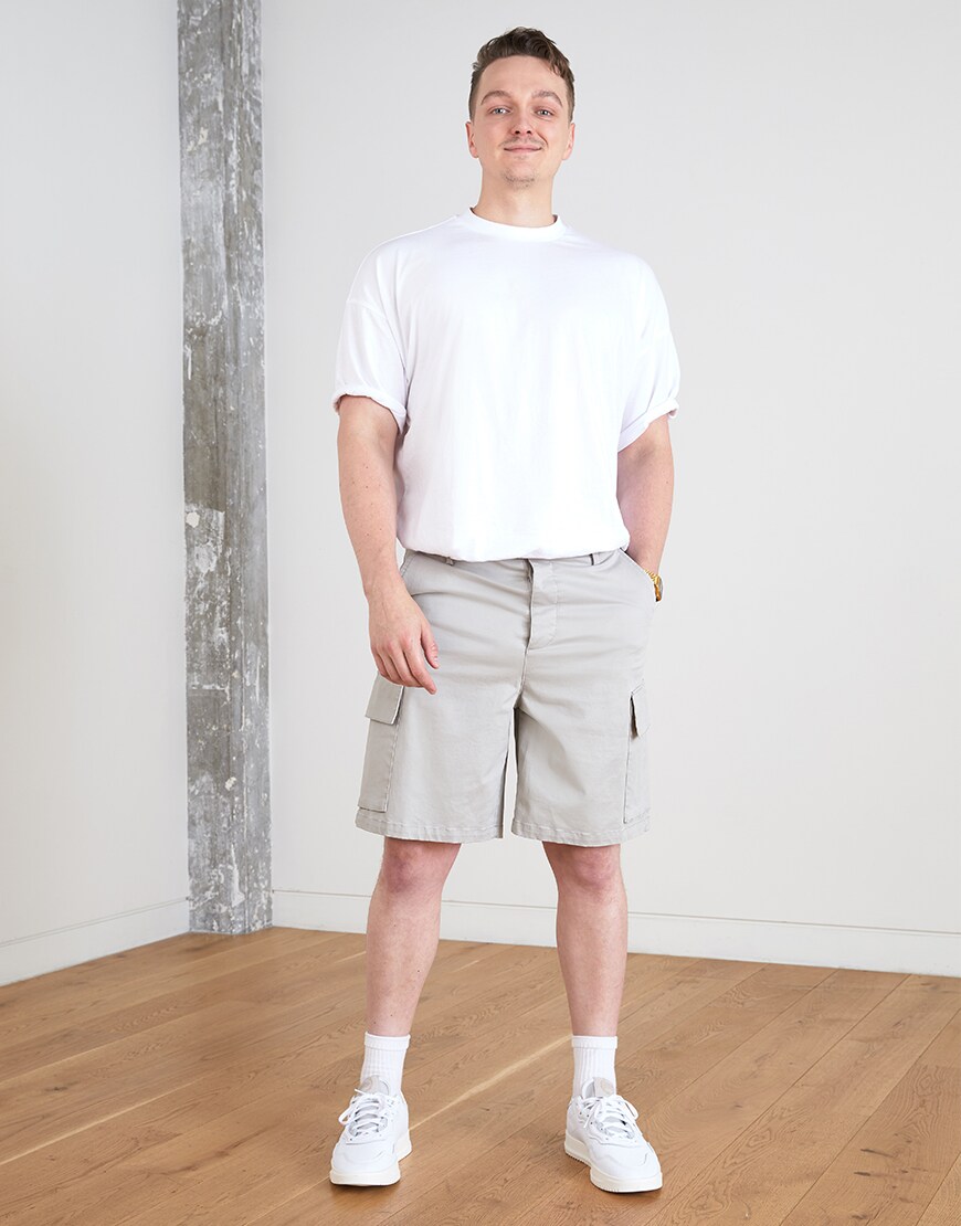 A picture of an ASOSer wearing a white T-shirt, cargo-style shorts and adidas trainers. Available at ASOS.