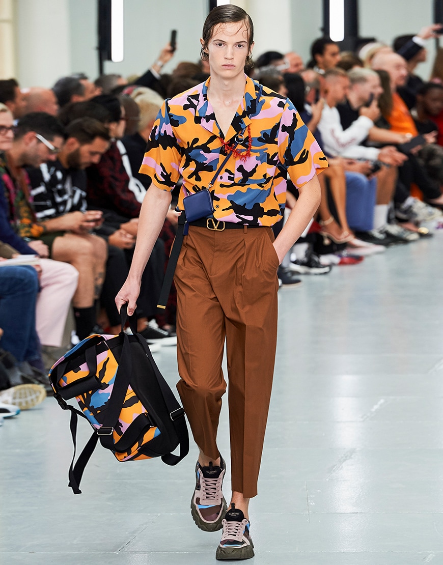 A picture of a model from the Valentino SS20 runway show wearing a bright camo shirt.