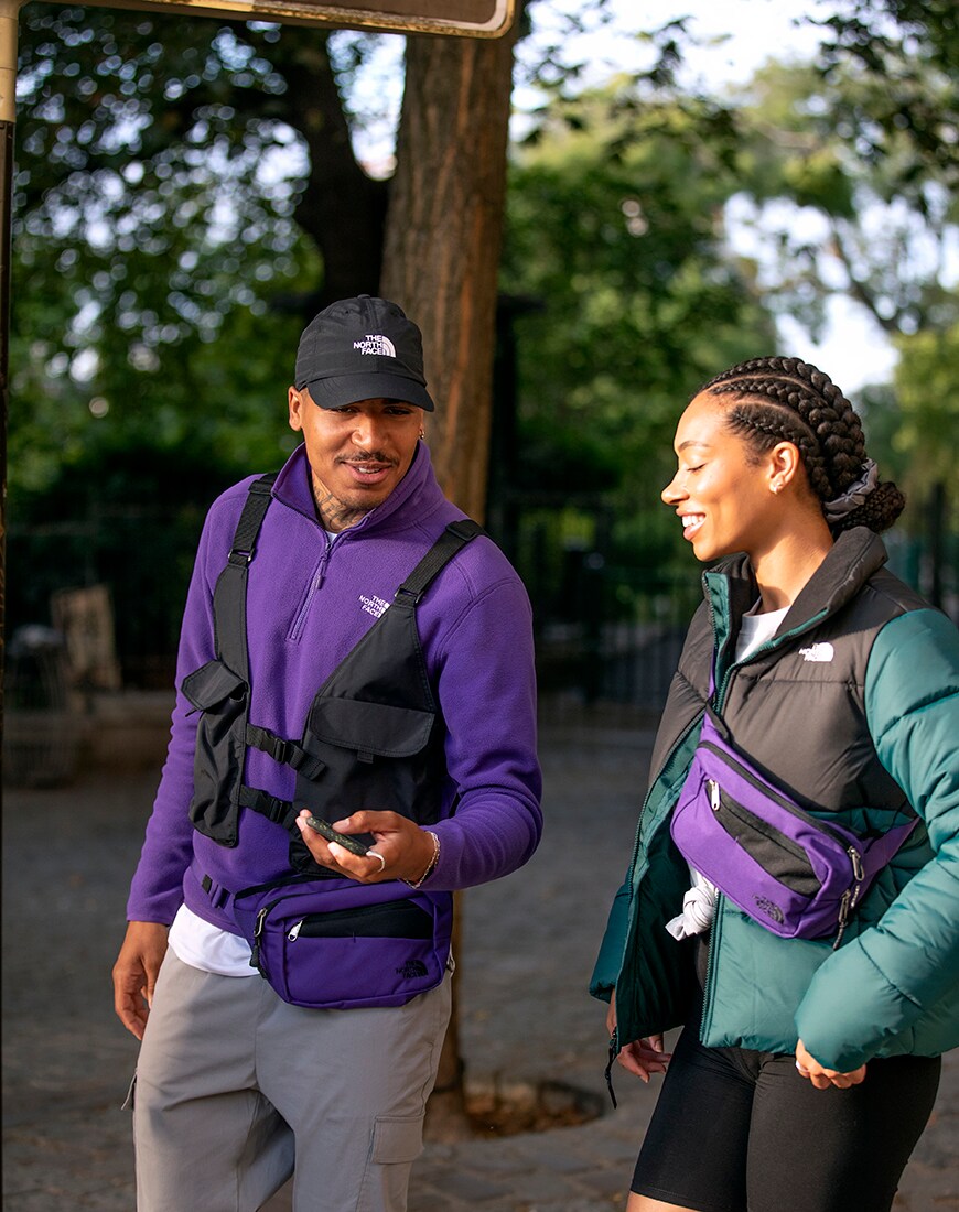 A picture of a man and woman wearing a puffer jacket and fleece from The North Face