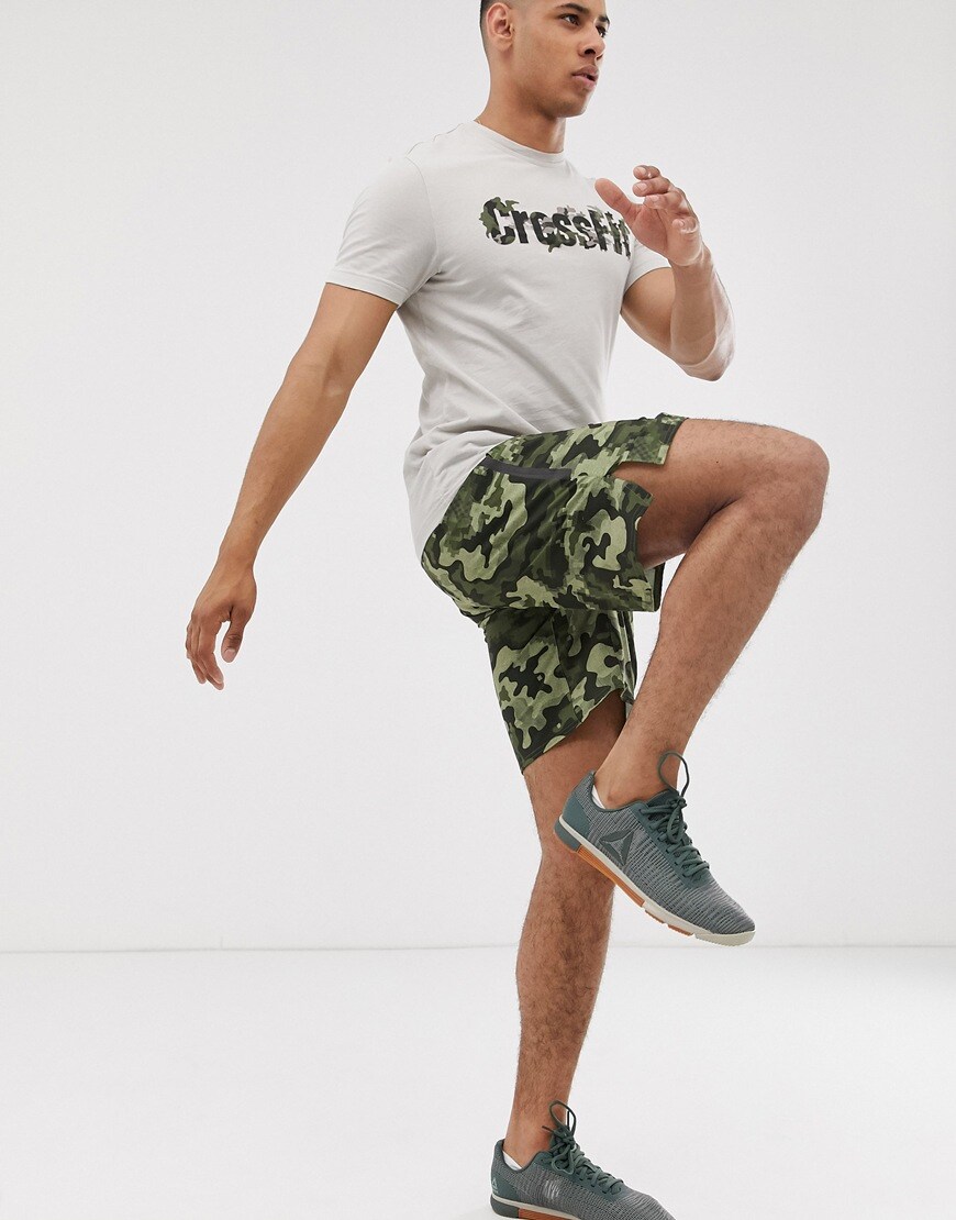 A picture of a man wearing Reebok camo print training shorts
