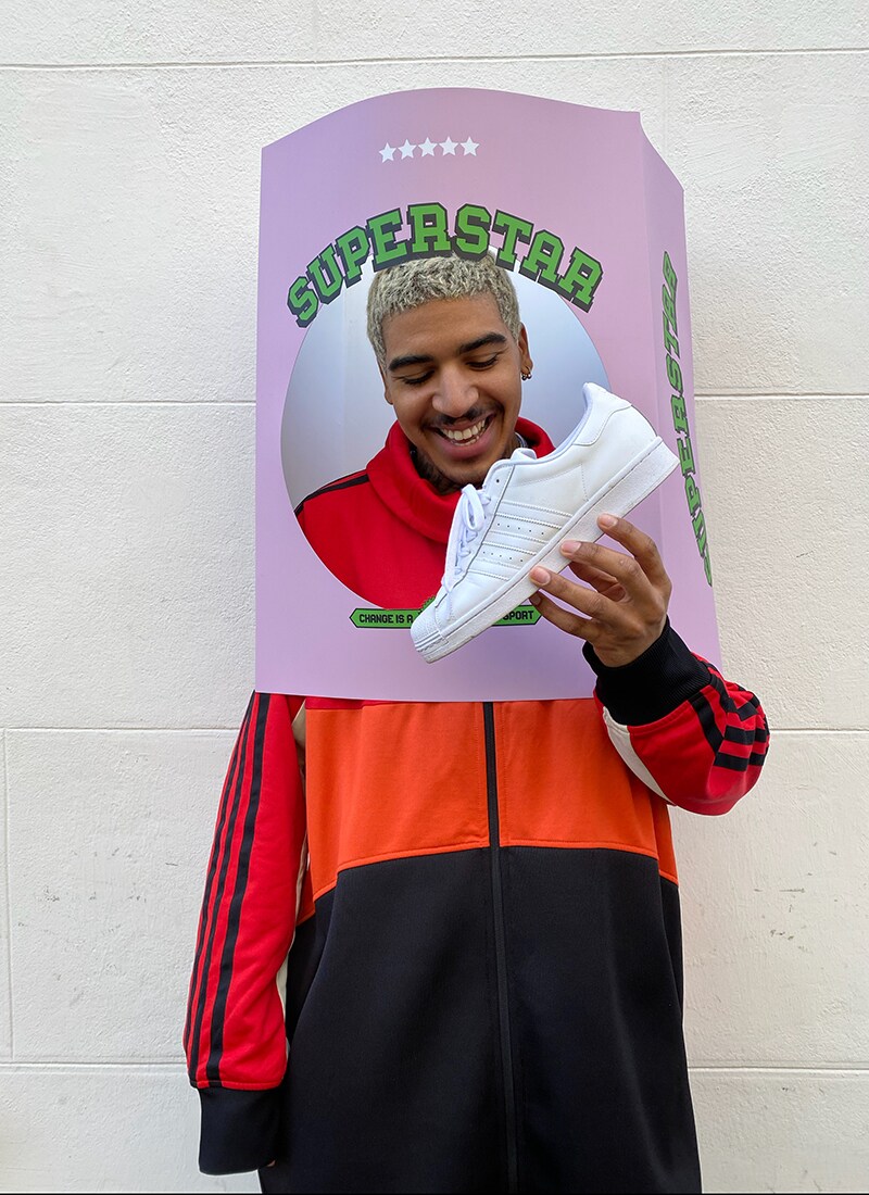 A picture of and ASOS Insider, ASOS Ruddy holding an all-white adidas Superstar trainer.