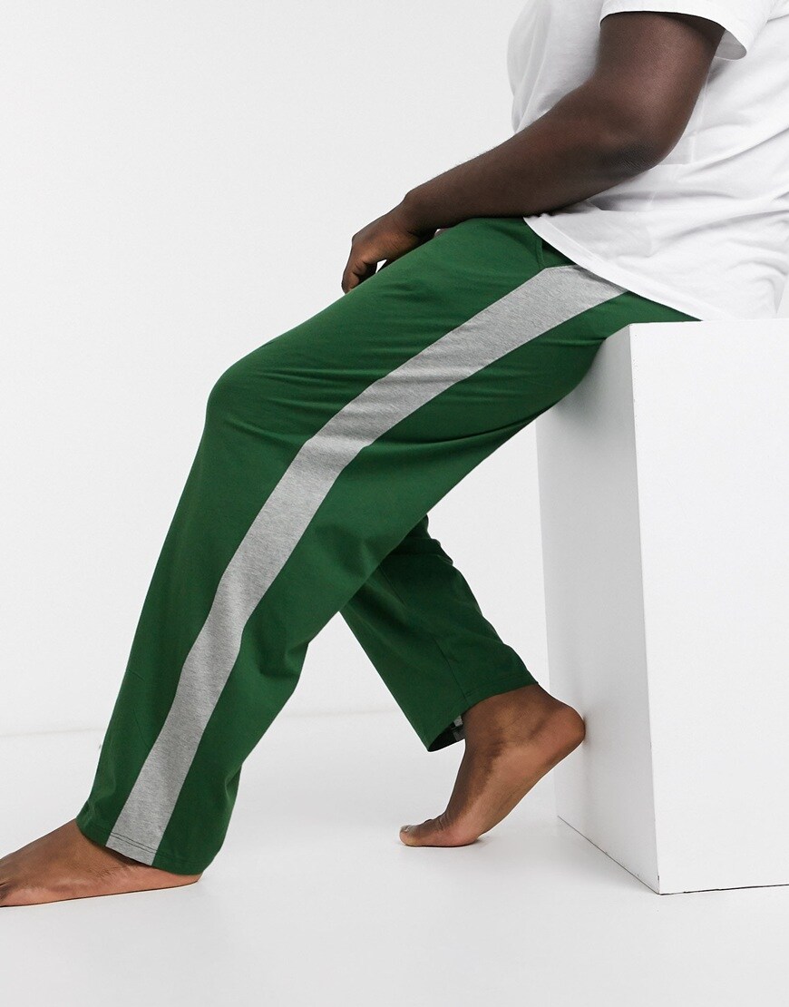 A picture of a plus-size model wearing a white T-shirt and green, striped joggers. Available at ASOS.
