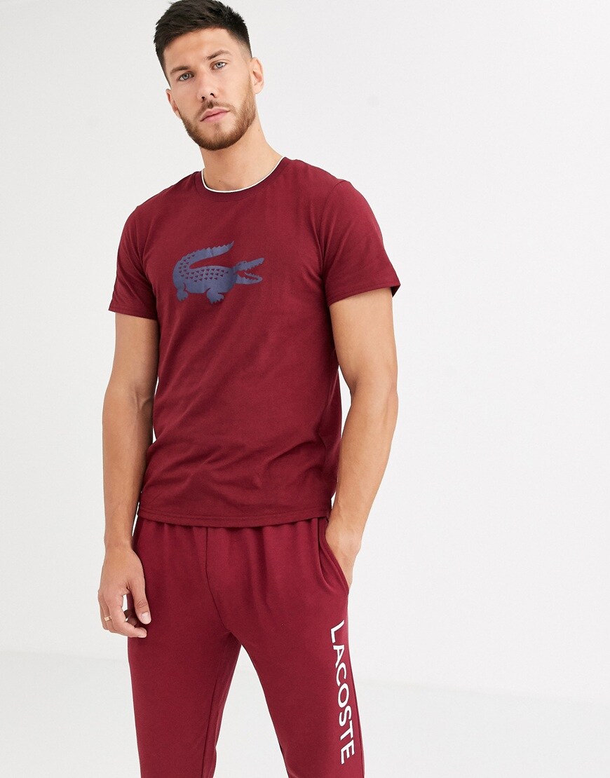 A picture of a model wearing a burgundy T-shirt from Lacoste's lounge range. Available at ASOS.