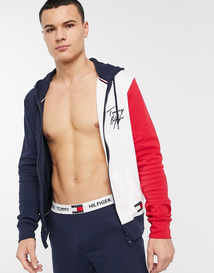 A picture of a man wearing a colour-blocked hoodie by Tommy Hilfiger. Available at ASOS.