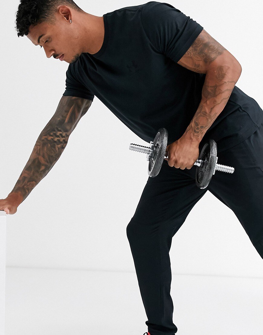 A picture of a model wearing a black T-shirt and shorts by Under Armour. Available at ASOS.