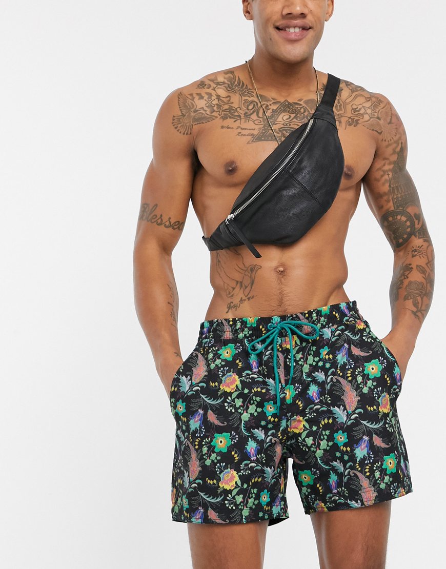 A picture of a model wearing a pair of recycled swim shorts featuring a colourful floral print by South Beach. Part of the ASOS Responsible Edit, available now.