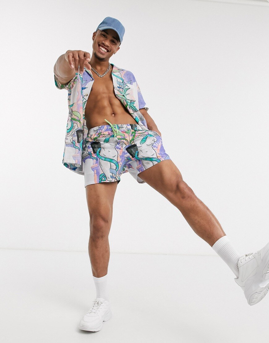 A picture of a model wearing a shirt-and-shorts co-ord featuring a bright postcard print. Available at ASOS.