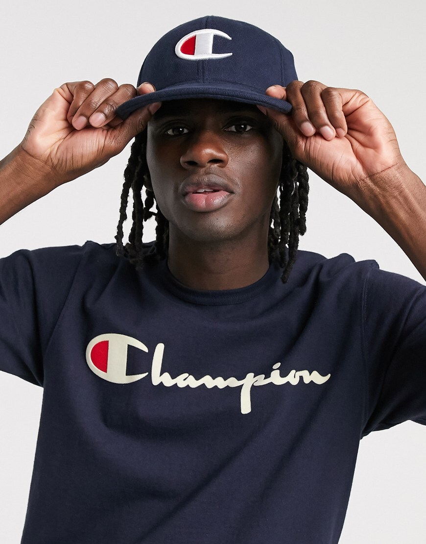 A picture of a model wearing a cap by Champion featuring an embroidered logo