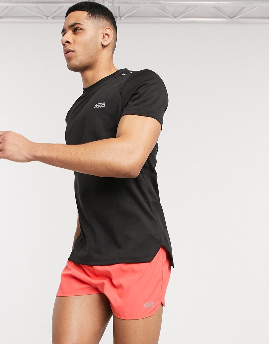 A picture of a model wearing a black T-shirt and orange shorts by ASOS 4505. Available now.