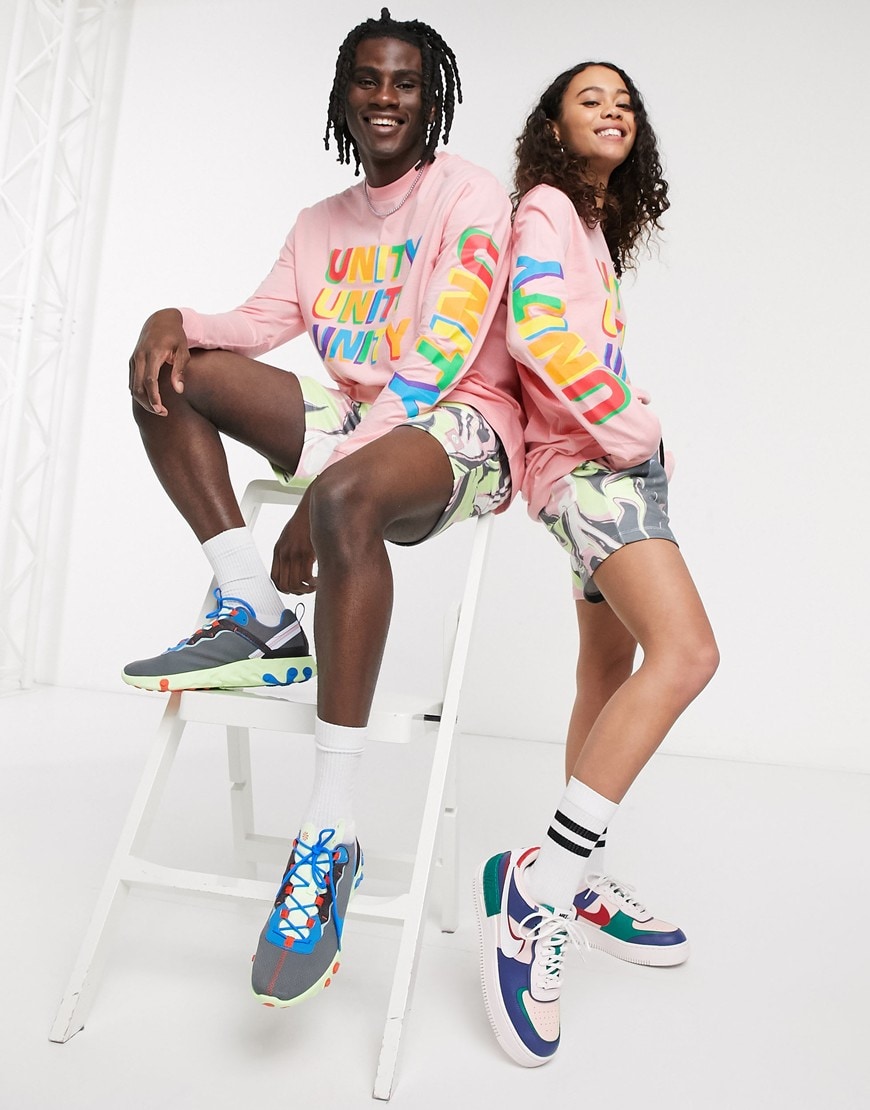 A picture of a male and female model both wearing a bright-pink long-sleeve T-shirt with a 'Unity' slogan print on the chest and sleeves. Part of the new ASOS X GLAAD collaboration.