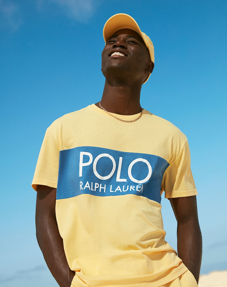 A picture of a model wearing a bright yellow T-shirt and cap from the exclusive Polo Ralph Lauren capsule collection. Available now.