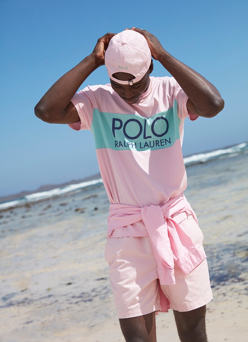 A picture of a model wearing a bright pink T-shirt and cap from the exclusive Polo Ralph Lauren capsule collection. Available now.