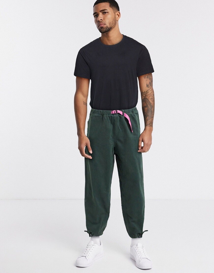 A picture of a man wearing khaki baggy trousers with a pink utility belt by Mossimo | ASOS STYLE FEED
