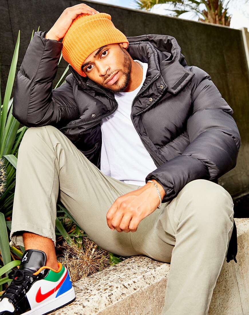  A picture of TV star Jordan Hames wearing a black puffer jacket, an orange beanie and beige chinos from the ASOS DESIGN Must-Haves collection. Available at ASOS | ASOS Style Feed