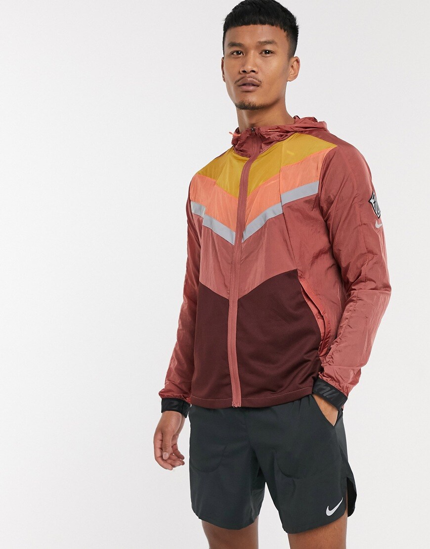 A picture of a model wearing a red Nike Running jacket. Available at ASOS.