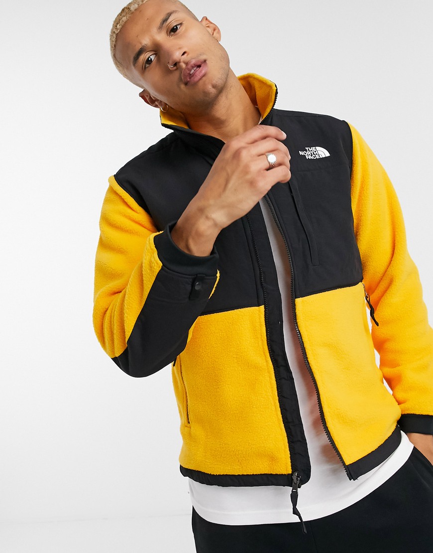 A picture of a model wearing a yellow and black Denali 2 fleece by The North Face. Available at ASOS.