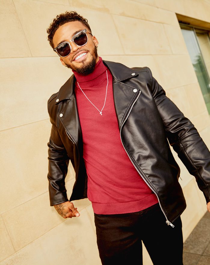 Michael Griffiths in black ASOS DESIGN leather jacket and a red roll neck jumper