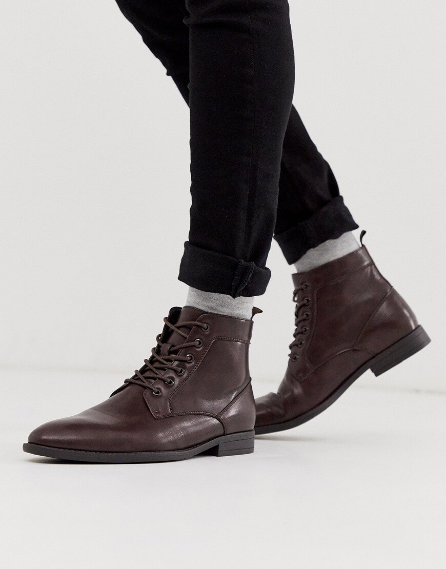 A picture of a model wearing brown laceup boots.  Available at ASOS |ASOS Style Feed