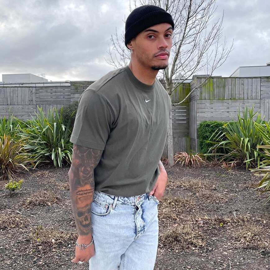 ASOS Insider Tyrone Clarke standing in a field with a beanie and Nike t-shirt on | ASOS Style Feed