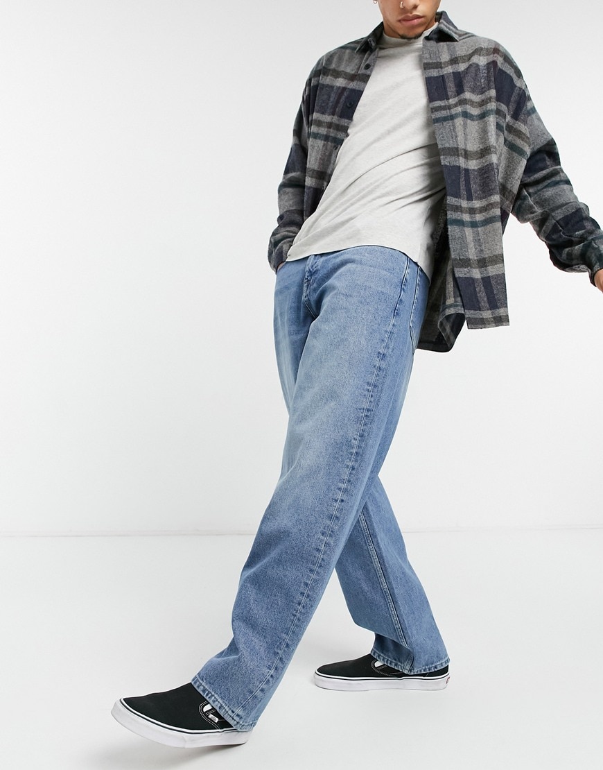 An image of a man wearing a pair of baggy jeans by ASOS Design | ASOS Style Feed