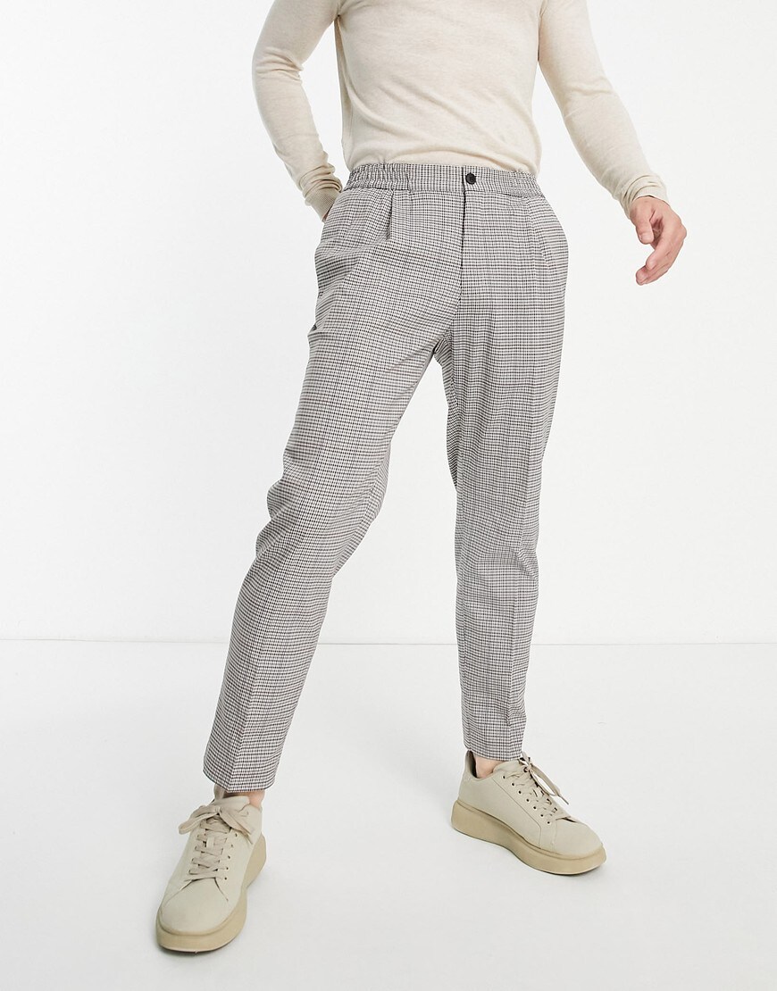 Model wears super fitting pupstooth trousers in beiges and greys. They're wearing beige trainers on their feet. | ASOS Style Feed