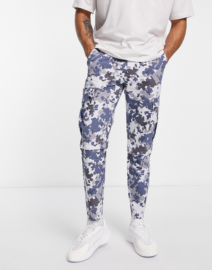 Man wearing camo cargo trousers.