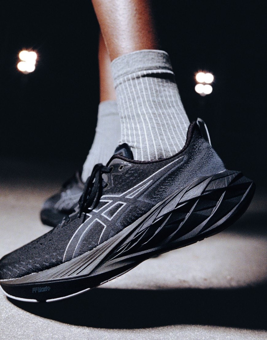 model wearing black asics trainers