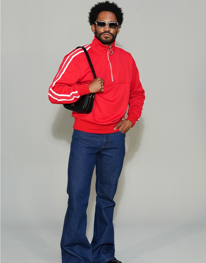 Kaytranada in a red tracksuit jacket and jeans