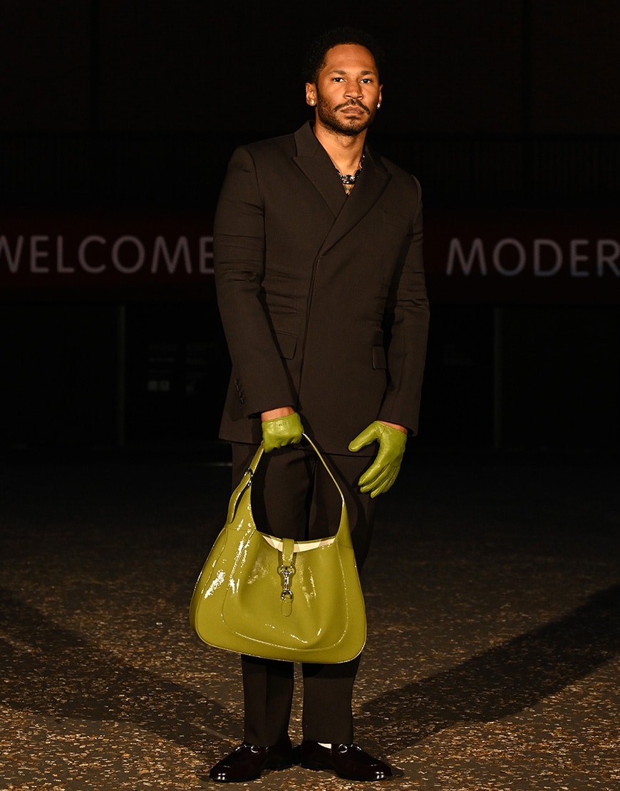 Kaytranada in a black suit with green accessories