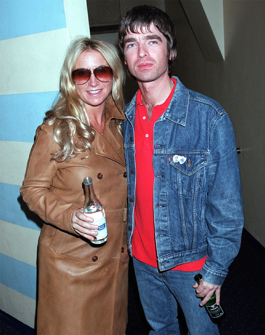 Noel Gallagher wearing a double denim outfit with a pop red polo shirt