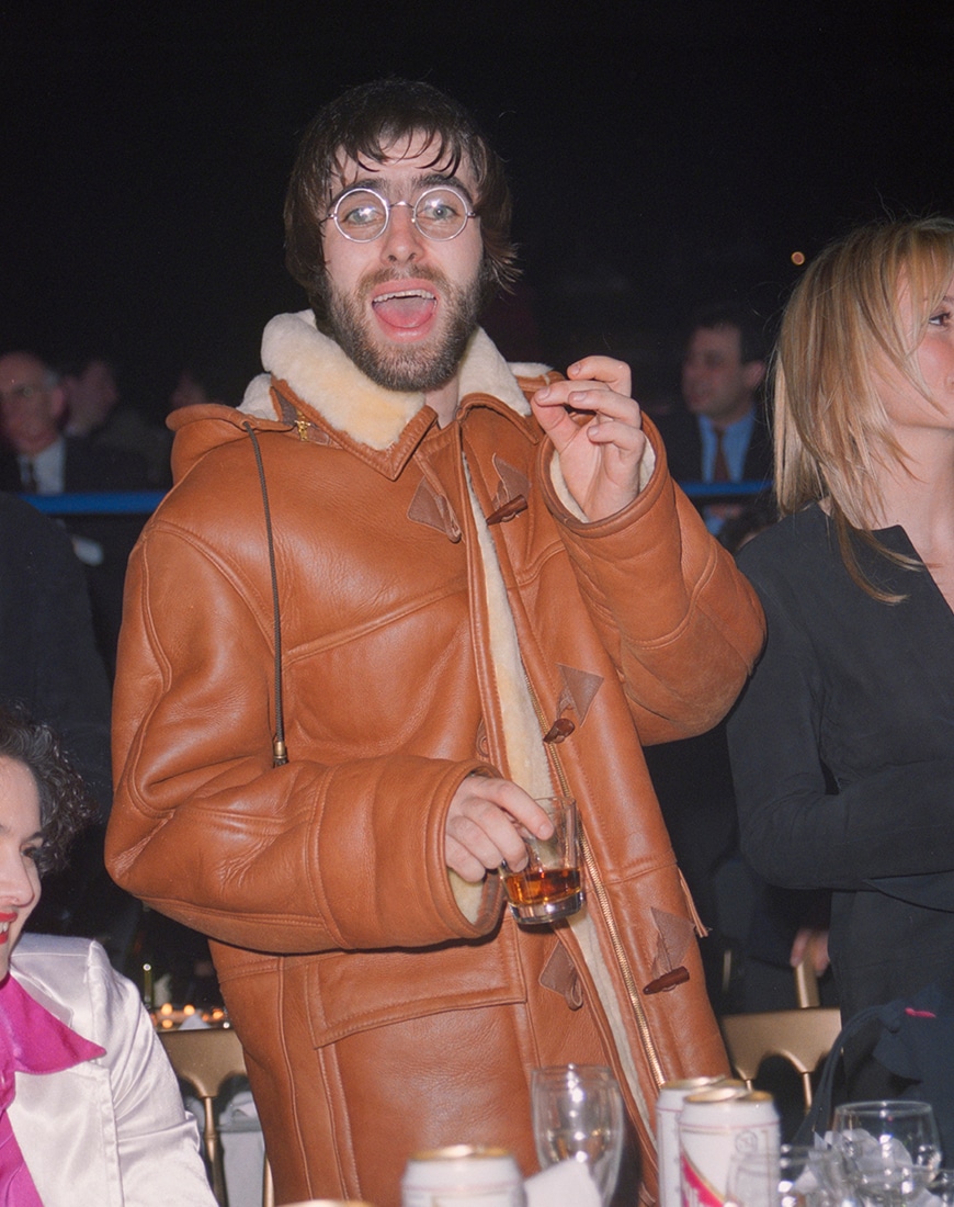 Liam Gallagher wearing tan coloured thick shearling aviator jacket
