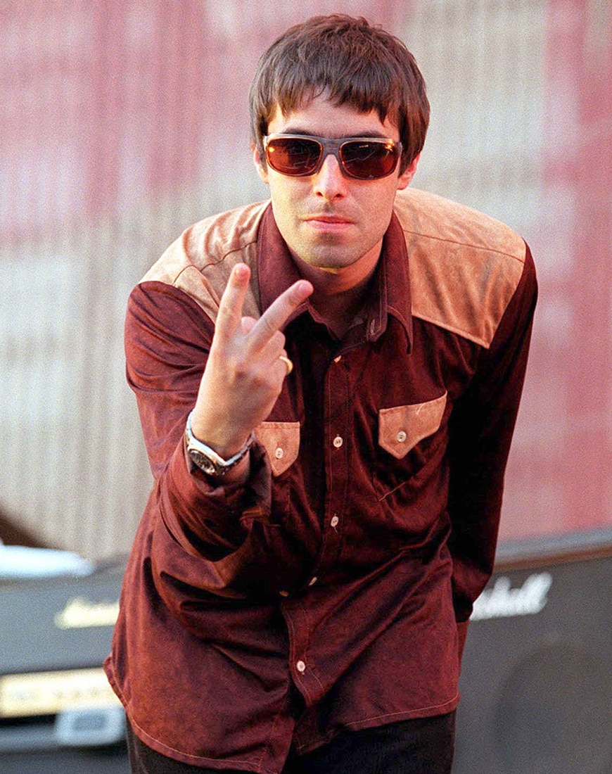 Liam Gallagher wearing cycling shades while holding up the peace sign
