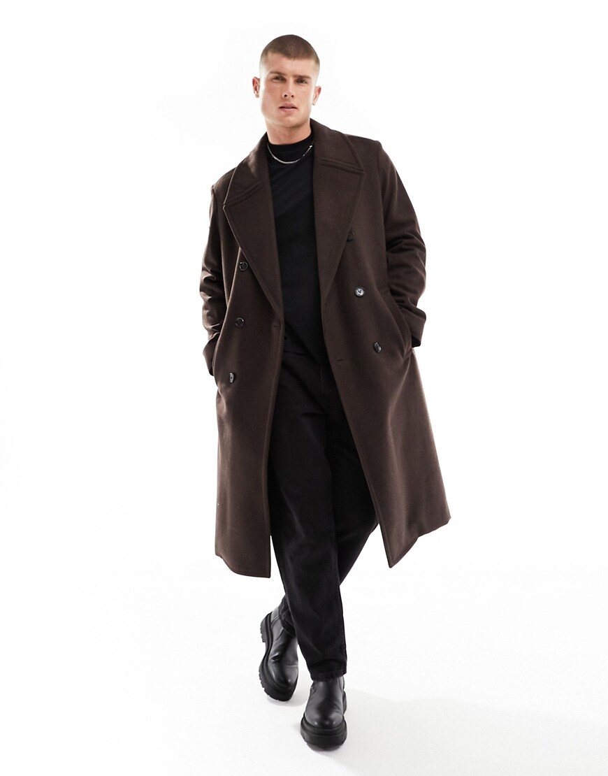Model wearing green overcoat and black outfit