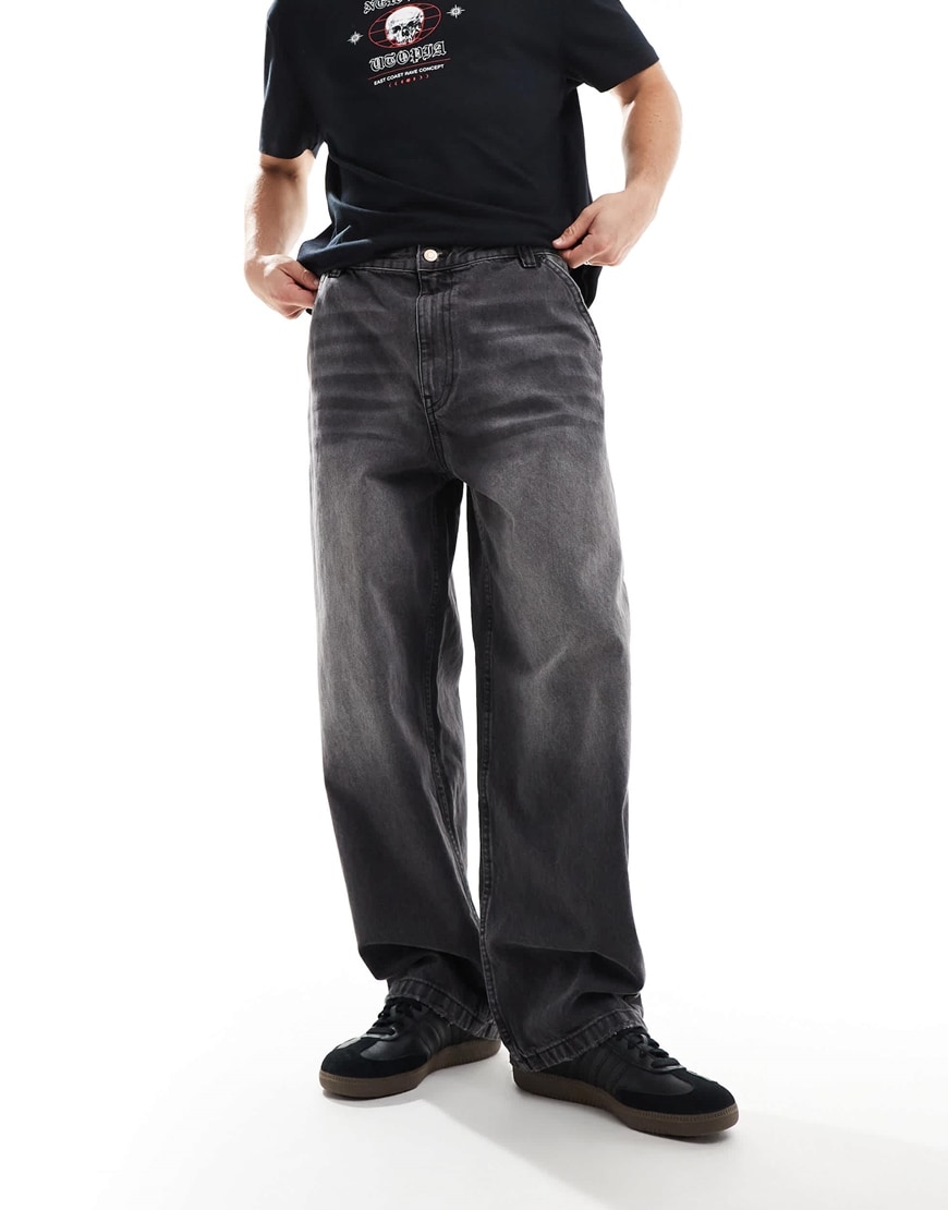Model wearing black graphic t shirt and grey baggy jeans