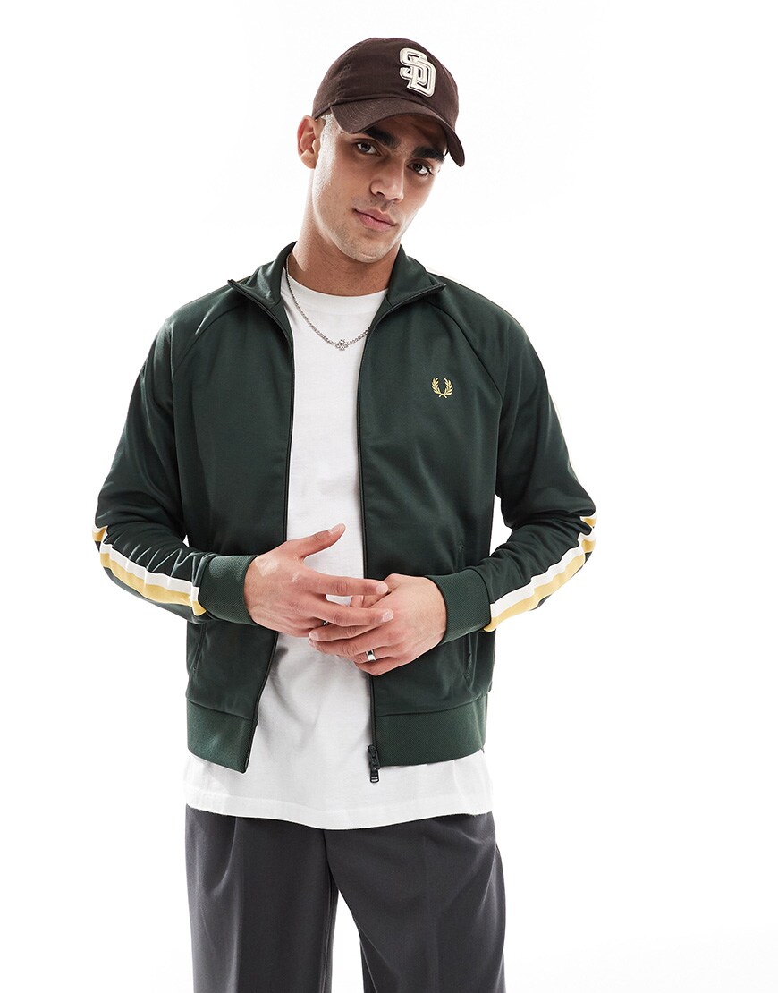A model wearing a green Fred Perry track top