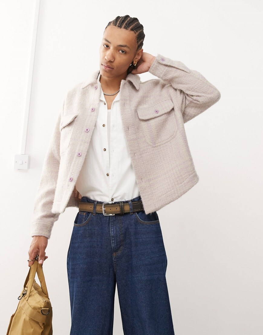 Model wearing white shirt with beige checkered jacket on top