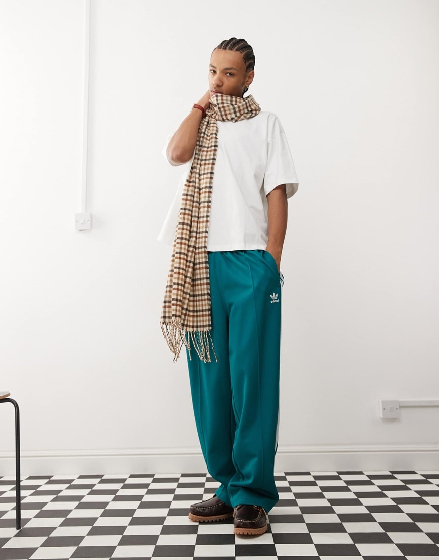 Model wearing white shirt, turquoise joggers and oversized checkered scarf